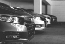 Grey and white image of cars parked in a row