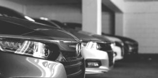 Grey and white image of cars parked in a row