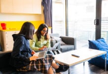Two students looking at their laptops