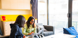 Two students looking at their laptops