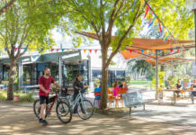 Students walking on campus with their bikes