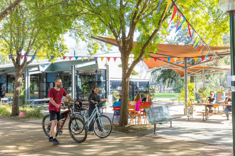 Students walking on campus with their bikes