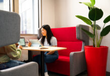 A student sitting at a desk in a comfortable-looking booth