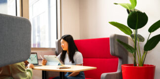 A student sitting at a desk in a comfortable-looking booth