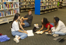 Five ways the Library can make uni life easier Students studying on the floor of the library with books