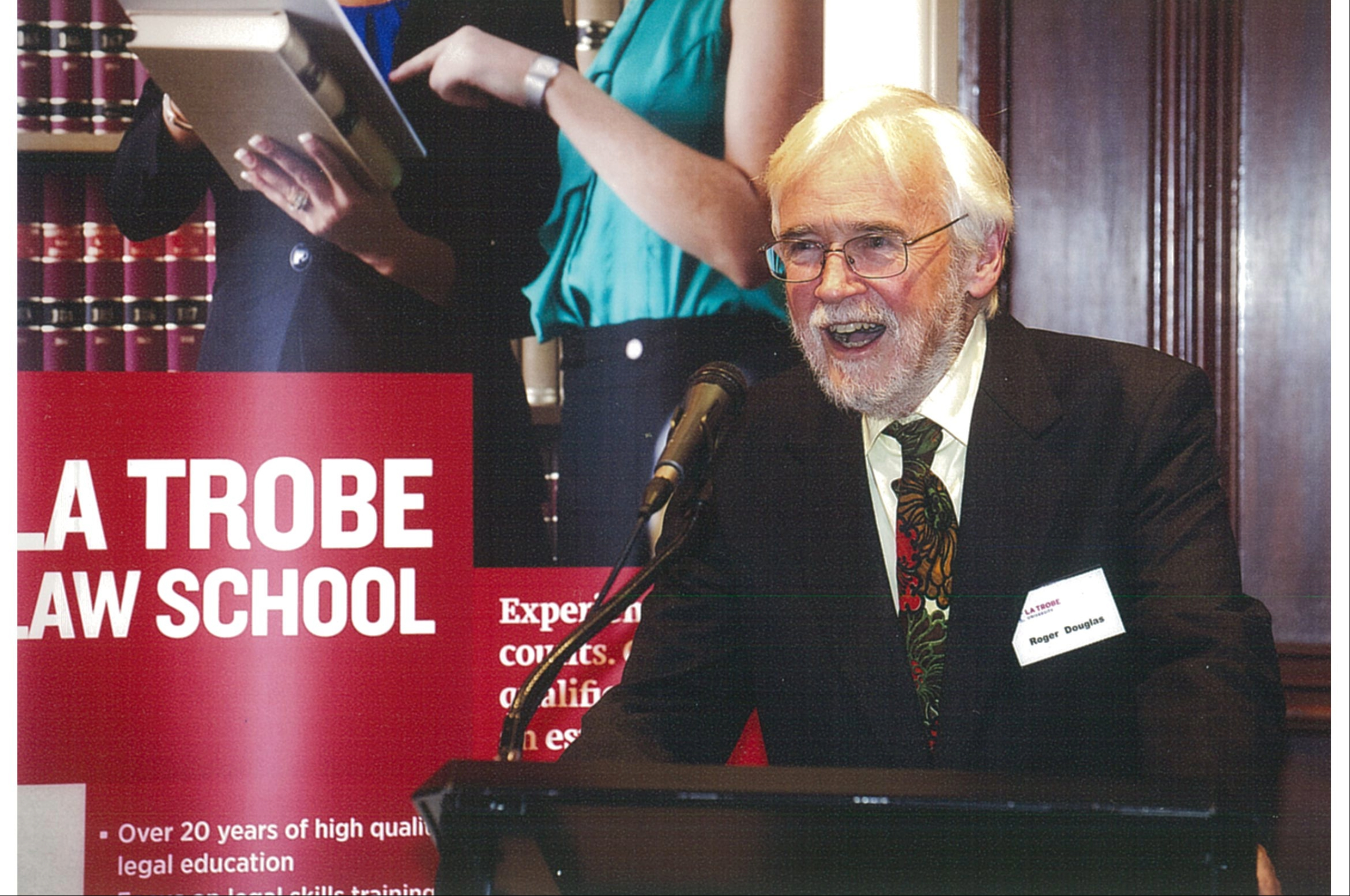 Roger Douglas at a podium speaking at his book launch