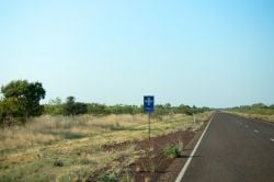 Roadside sign in a rural area suggesting there is a hospital nearby.