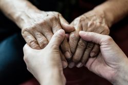 Two people's hands holding one another