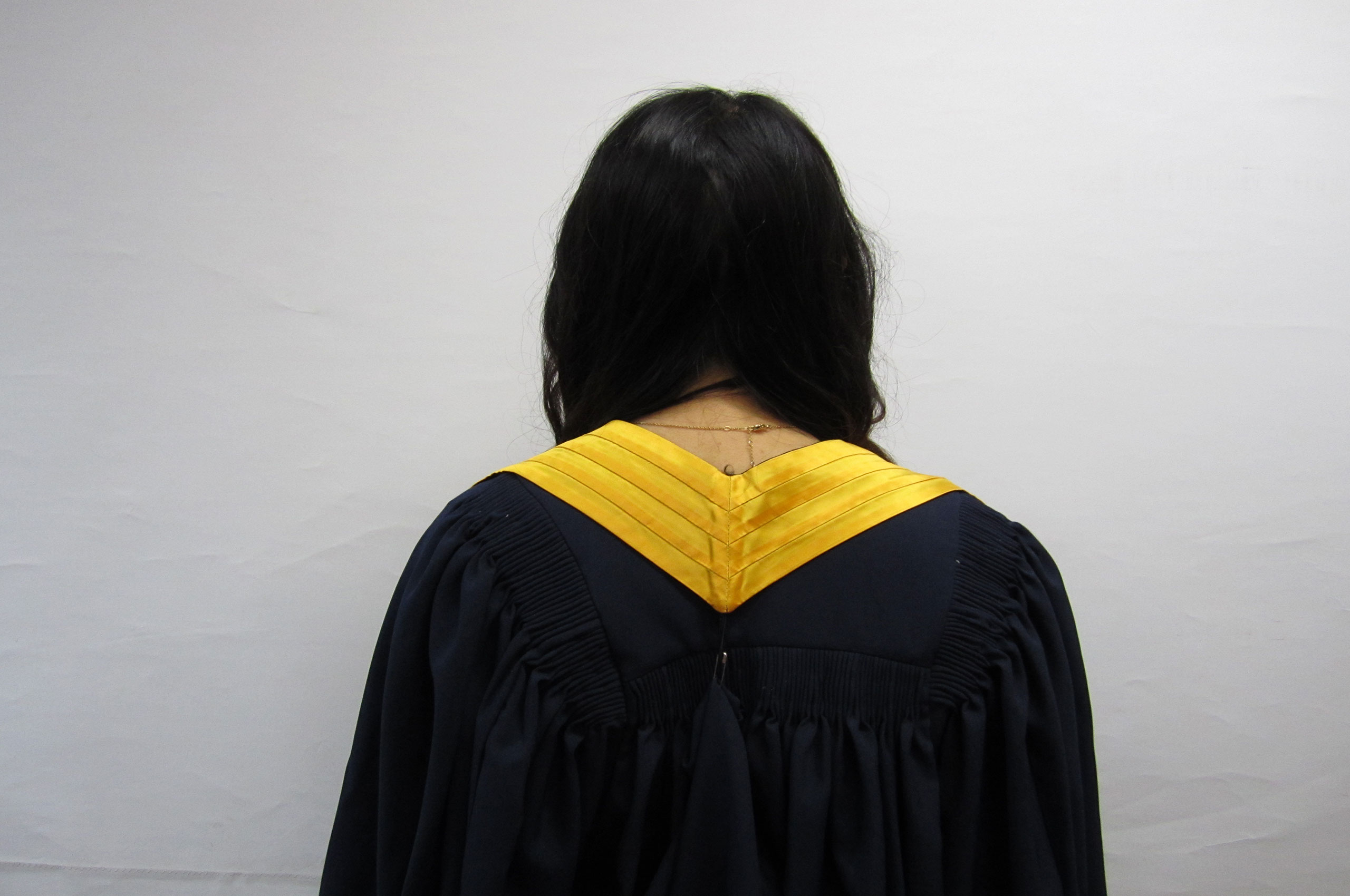 back of diploma graduation gown, with yellow silk sash