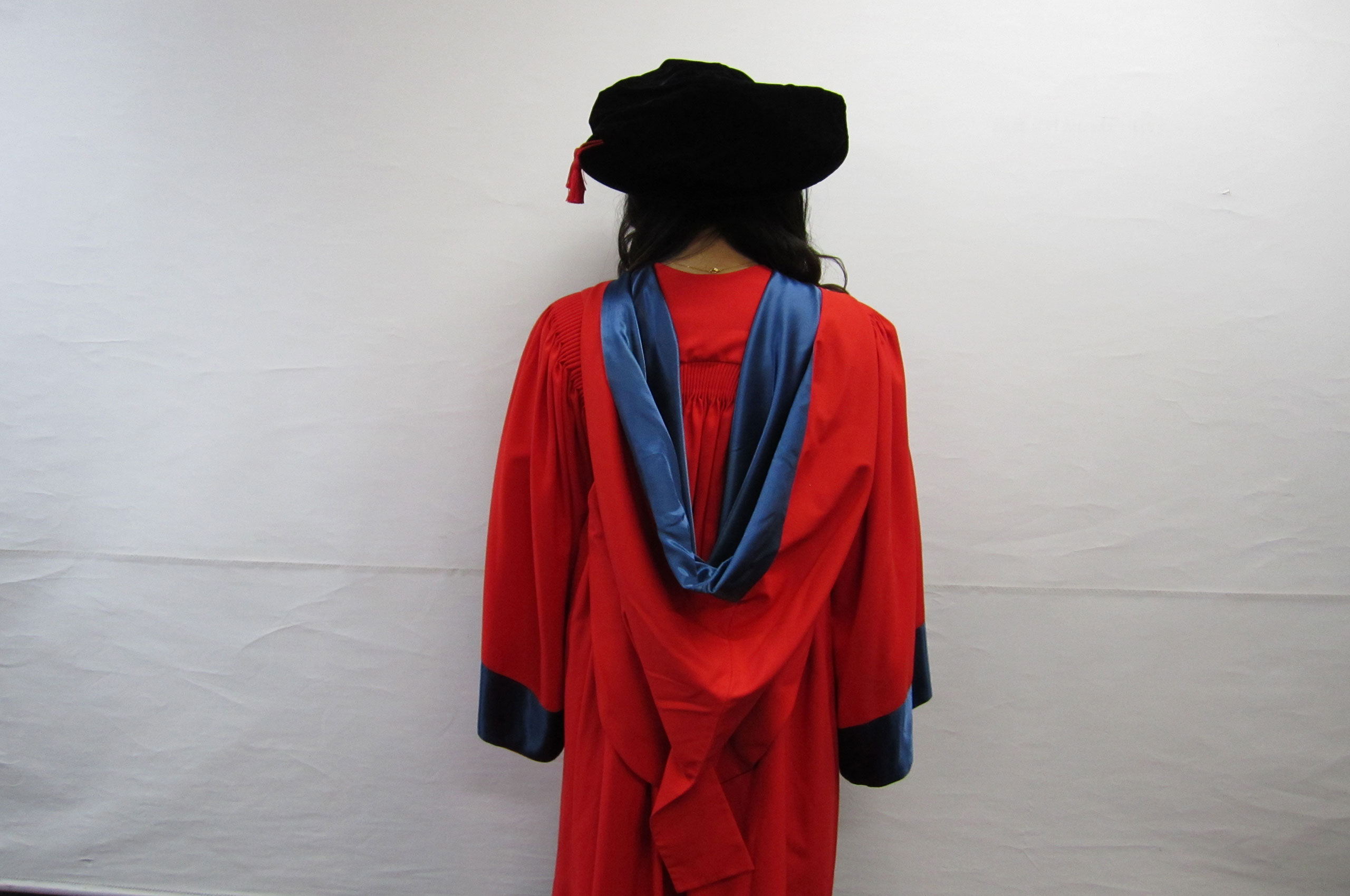 back of doctor of philosophy gown, deep red silk gown with blue cuffs and blue silk hood