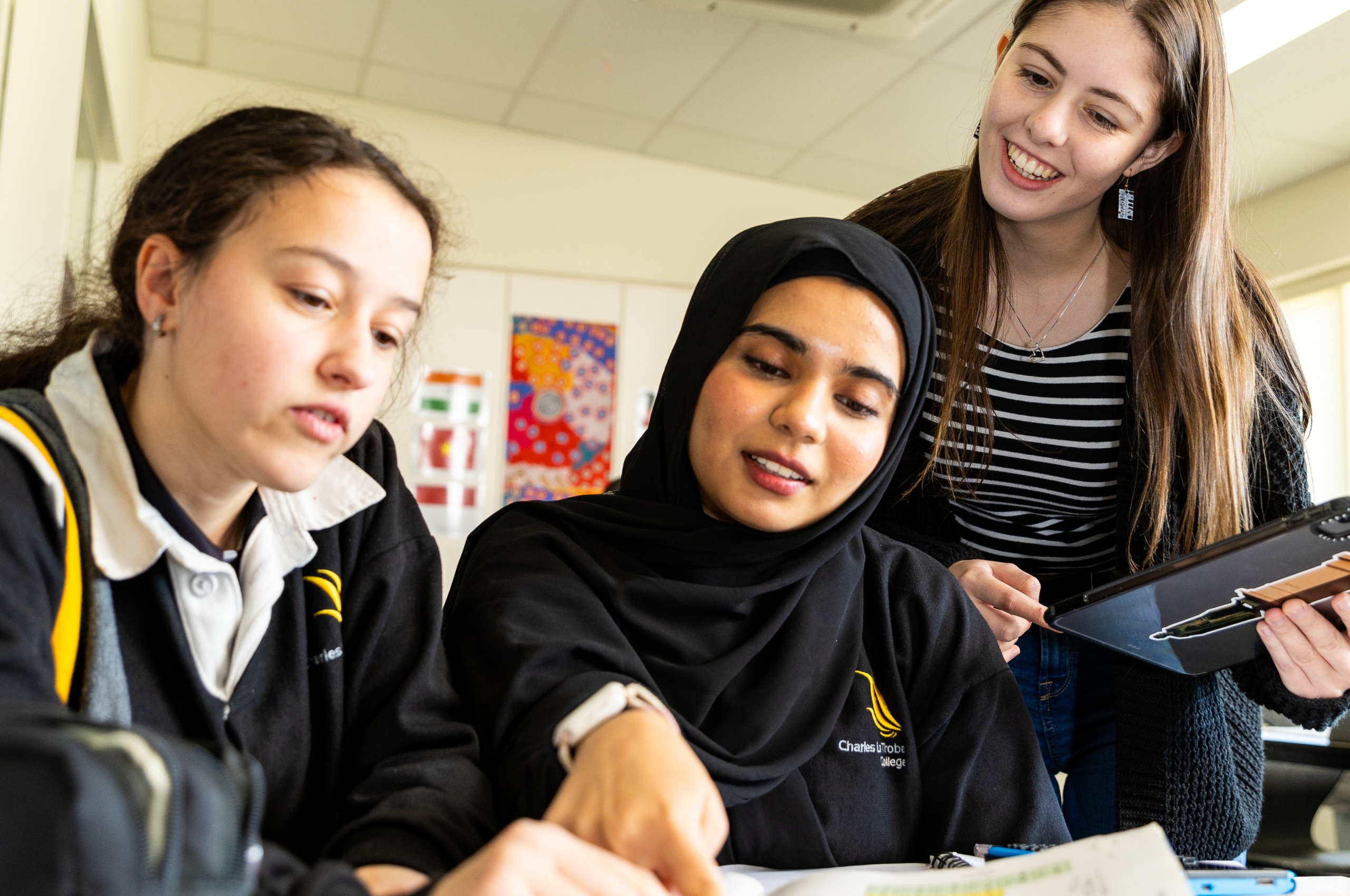 A mentor helping students with work in a school