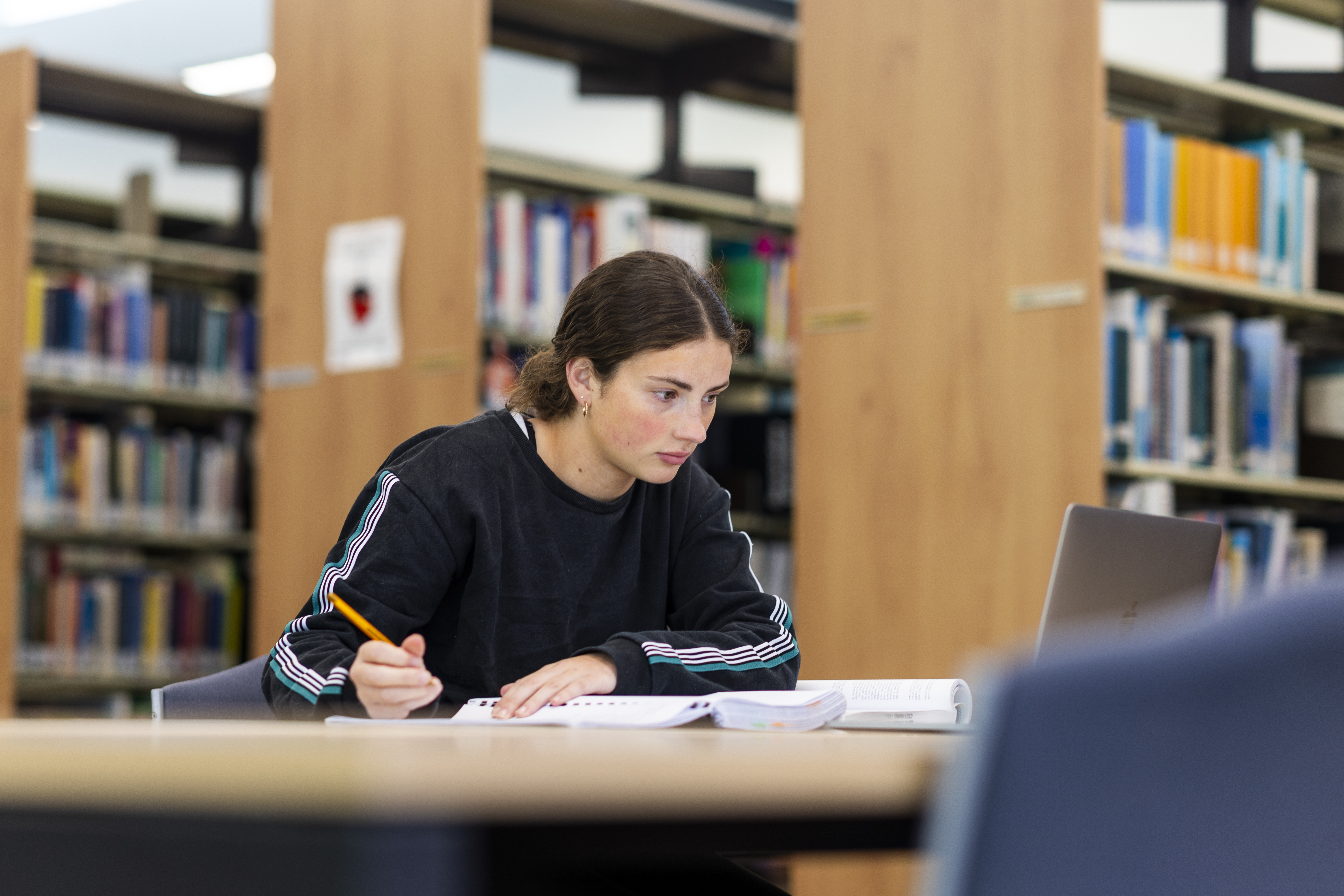 A student studying at a table in the library.