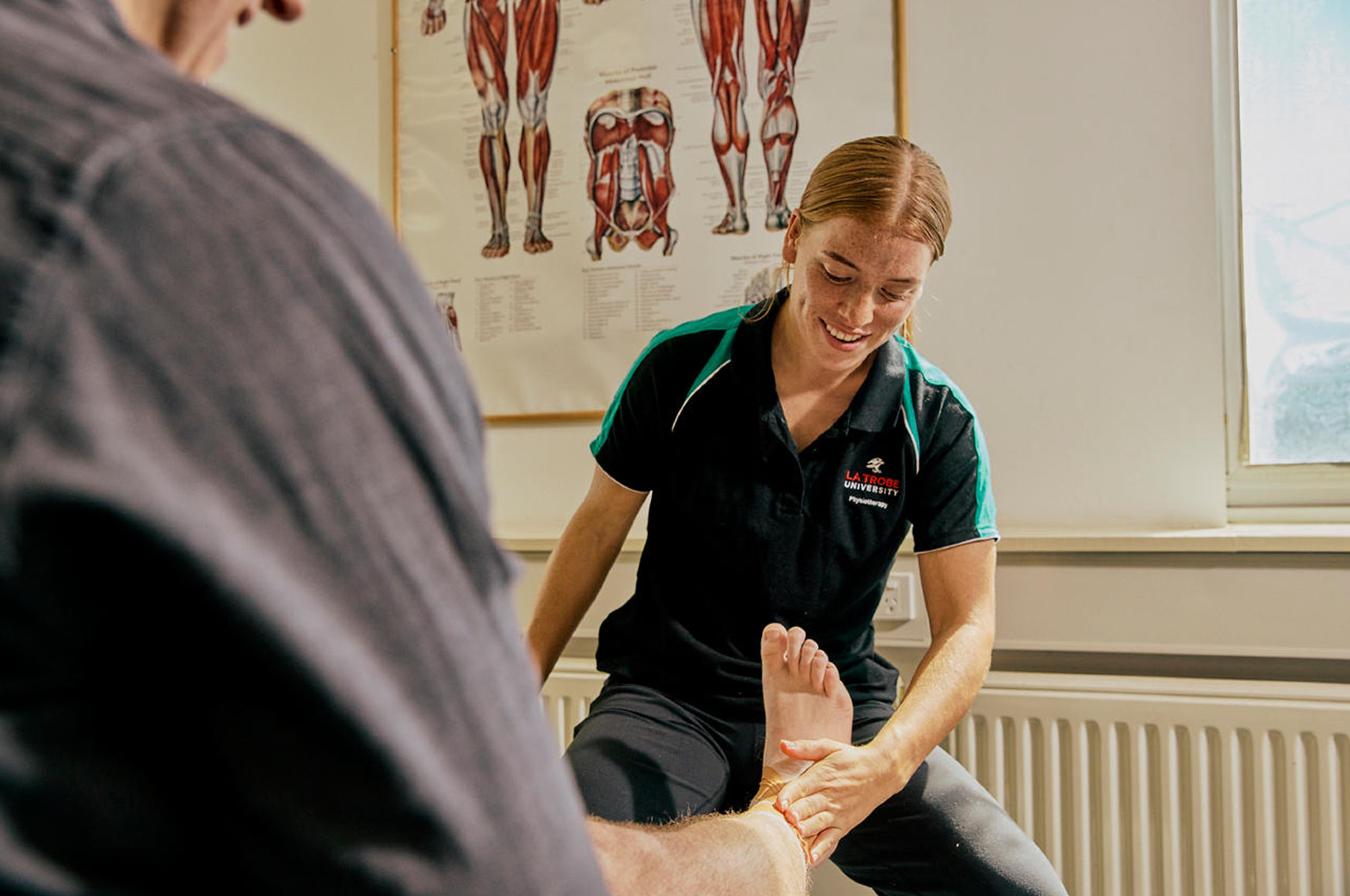 A podiatrist touching a patients ankle. 